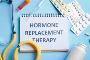 Notebook with text Hormone Replacement Therapy and medications on light blue background