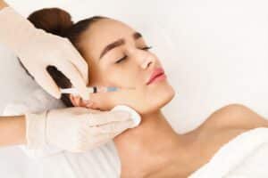 Woman closes her eyes, relaxing peacefully during Sculptra® injections
