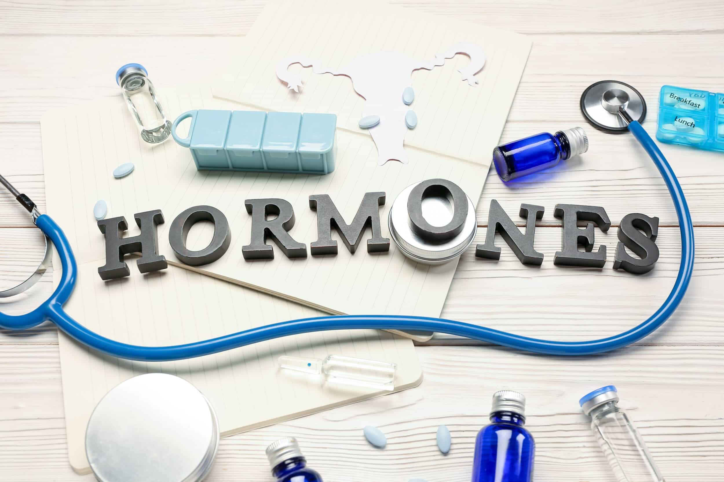 A stethoscope on a white background, with the word "hormones" spelled out beneath it