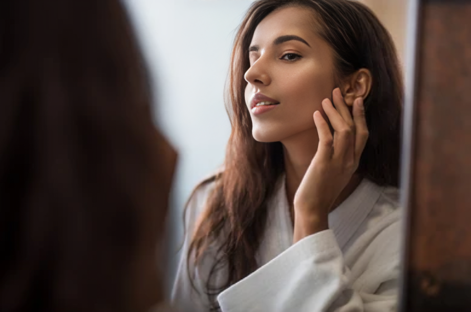 Natural Collagen Stimulation in Lone Tree, CO 1 Woman looking in the mirror after natural collagen stimulation in Lone Tree