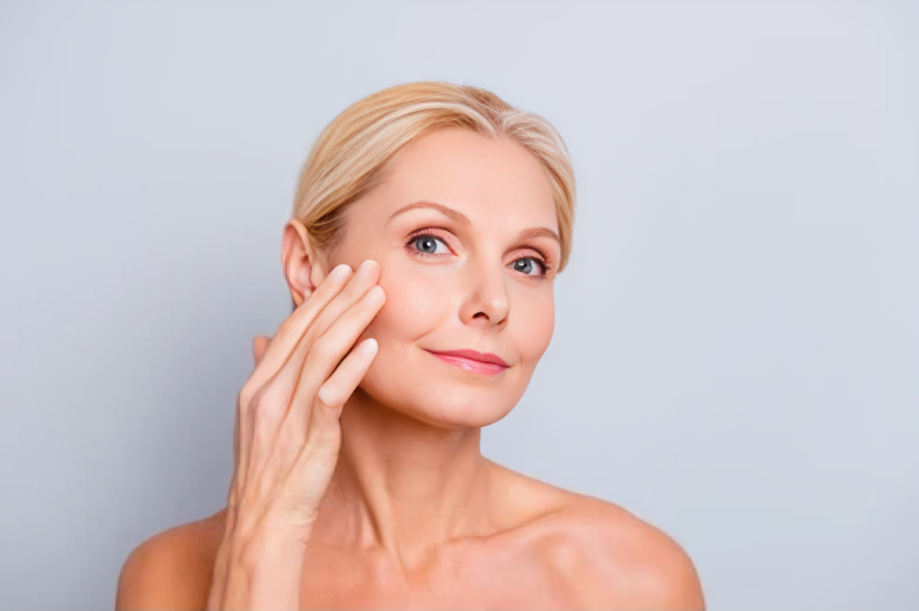 Natural Collagen Stimulation in Lone Tree, CO 2 Woman touching her cheek after Sculptra in Lone Tree